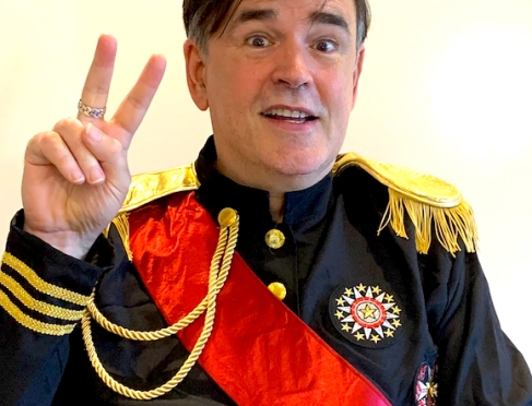 Image of Tim wearing a military uniform and making a peace sign 