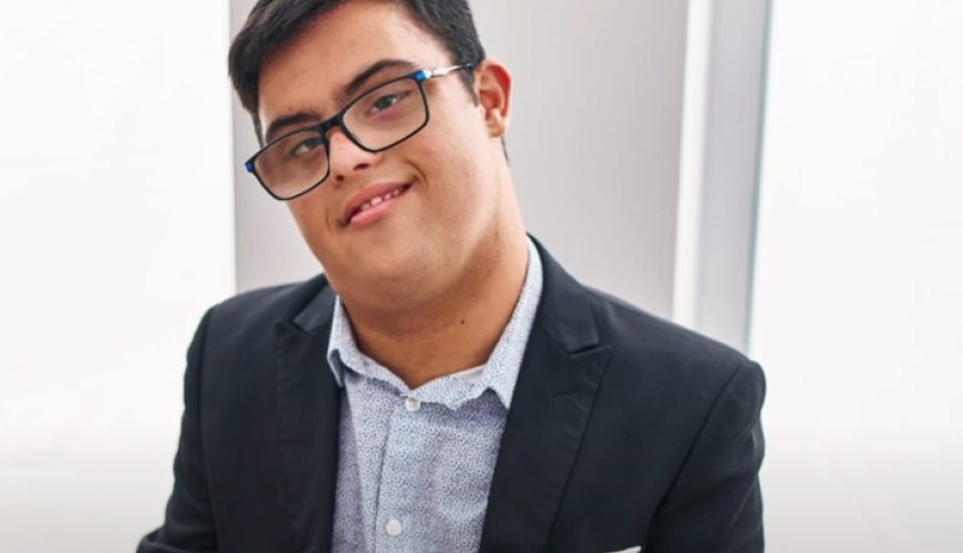 image of a man wearing a suit jacket and glasses with a takeaway cup in his hand