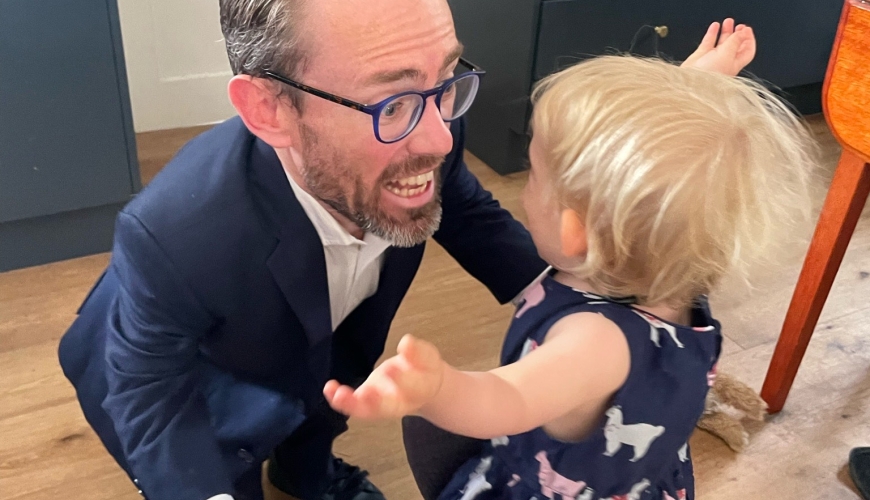 Image of Sam about to give his toddler a cuddle