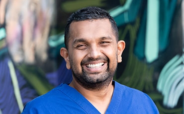 Dr Dinesh Palipana in blue hospital scrubs